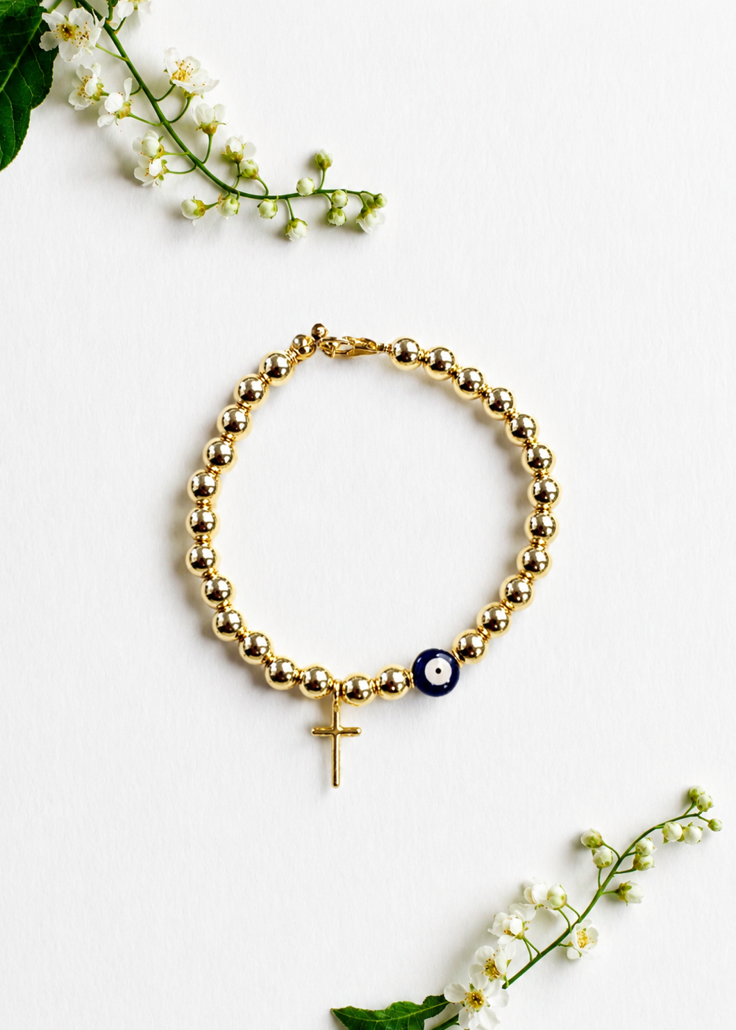 Gold Mati Greek evil eye bracelet with a delicate cross and gold beads, handmade and made to order in Canada, symbolizing faith, strength, and protection.