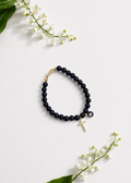Black Mati Greek evil eye bracelet with a gold cross and black beads, handmade and made to order in Canada, symbolizing faith, strength, and protection.