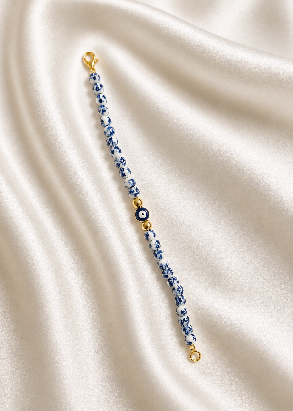 Blue and white beaded bracelet featuring a blue Greek evil eye charm, inspired by Mediterranean style and the colors of Santorini. Handmade and made to order in Canada.