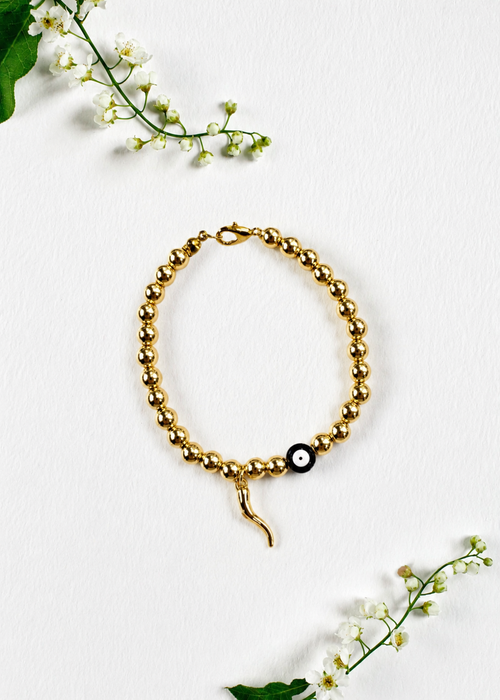 Handmade gold evil eye and Italian horn cornicello bracelet inspired by the traditional Italian symbol of protection from the malocchio, made to order in Canada.